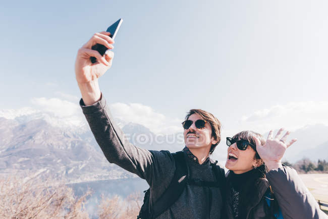 Пара, делающая селфи со смартфона — стоковое фото