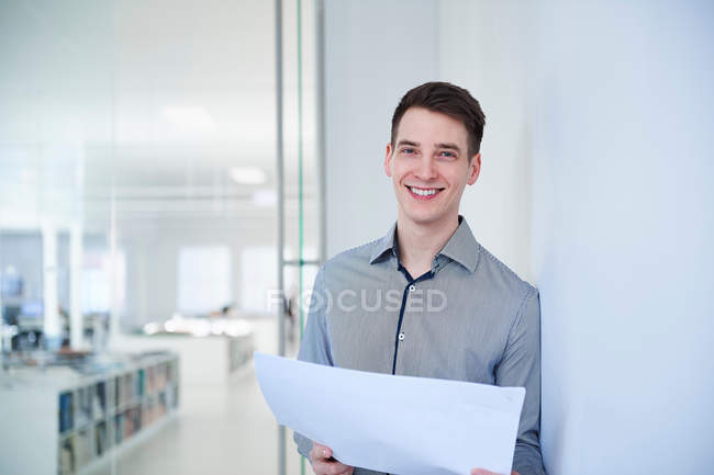 Architect in office holding blueprints — Stock Photo