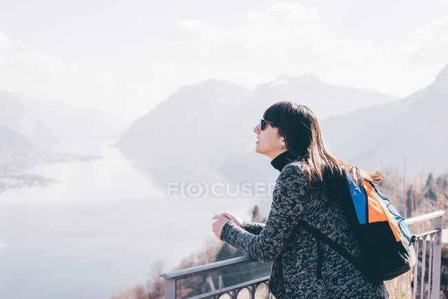 Woman looking out over lake and mountains — Stock Photo
