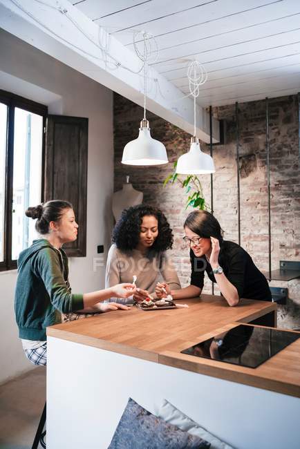 Друзья сидят за кухонным столом — стоковое фото