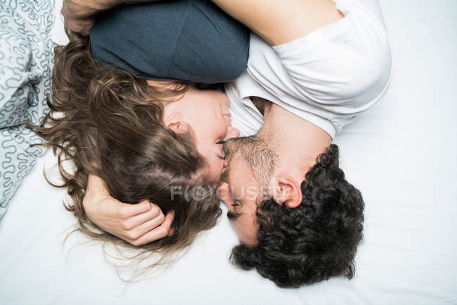 Coppia sdraiata a letto e abbracciata — Foto stock