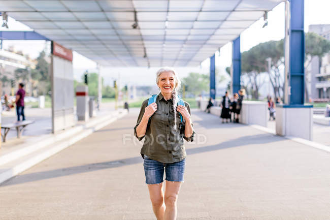 Female backpacker walking in bus station — Stock Photo