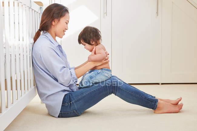 Woman playing with baby daughter — Stock Photo