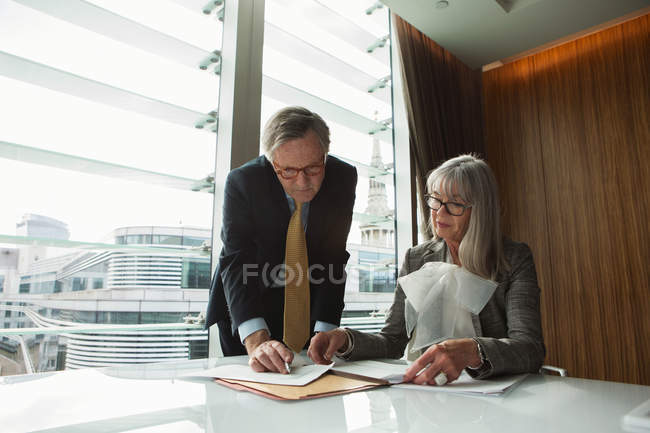Homme d'affaires et femme d'affaires lisant et analysant le rapport — Photo de stock