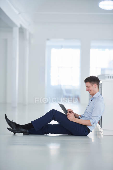 Homme au bureau assis sur le sol — Photo de stock