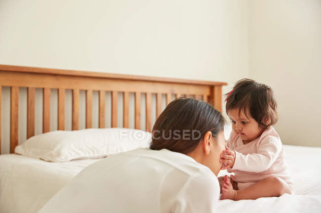 Baby girl touching mothers face — Stock Photo