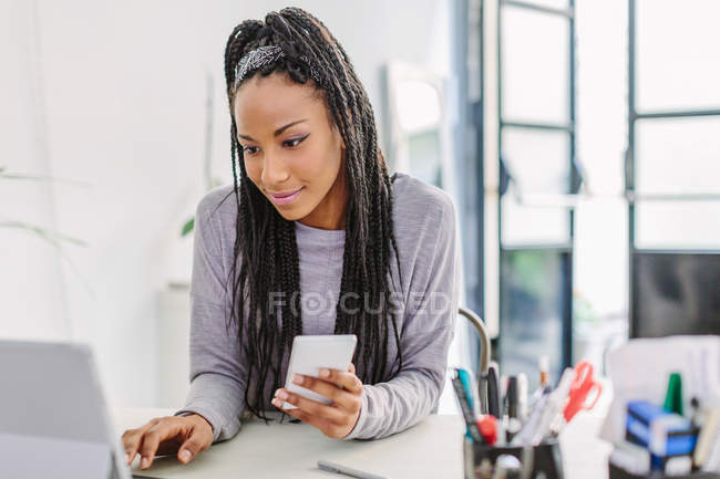 Mulher usando computador e telefone celular — Fotografia de Stock
