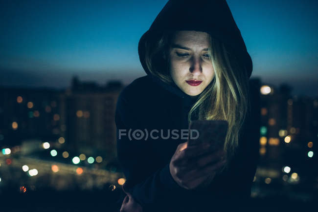 Young woman sitting on rooftop — Stock Photo