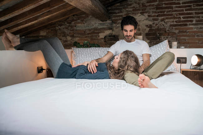 Couple reclining on bed — Stock Photo