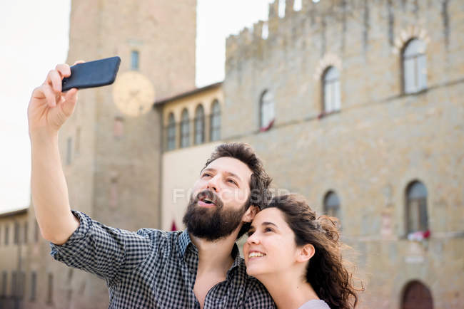 Pareja tomando selfie por la Catedral de Arezzo - foto de stock