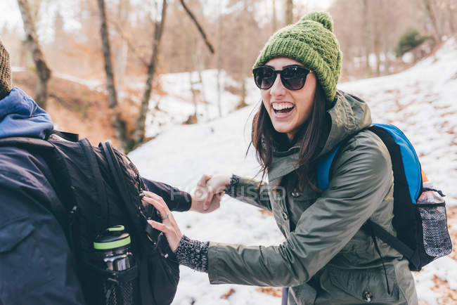 Hiking couple laughing in snowy forest — Stock Photo