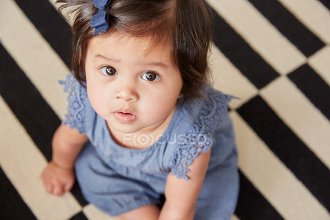 Bébé fille assis sur tapis — Photo de stock