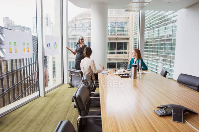 Empresarias preparando presentación en sala de reuniones - foto de stock