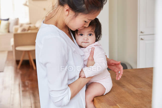 Mujer abrazando bebé hija - foto de stock