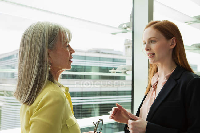 Geschäftsfrauen reden am Fenster — Stockfoto