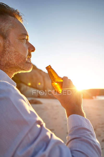 Homme tenant une bouteille de bière — Photo de stock