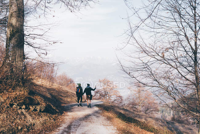 Caminhadas casal caminhadas ao longo da estrada rural — Fotografia de Stock