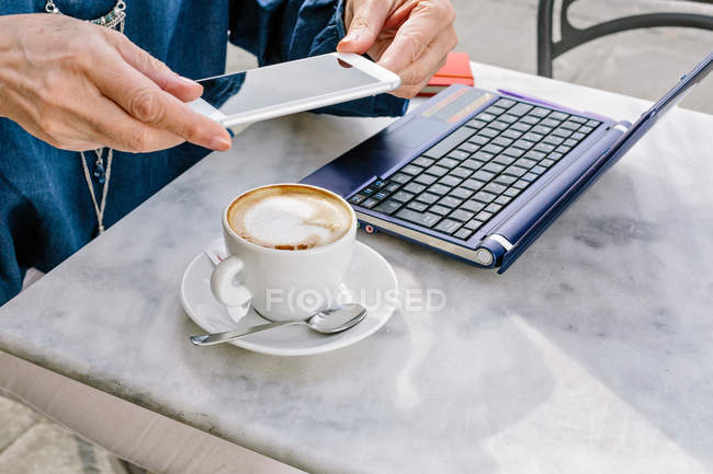 Hands of mature woman holding smartphone — Stock Photo