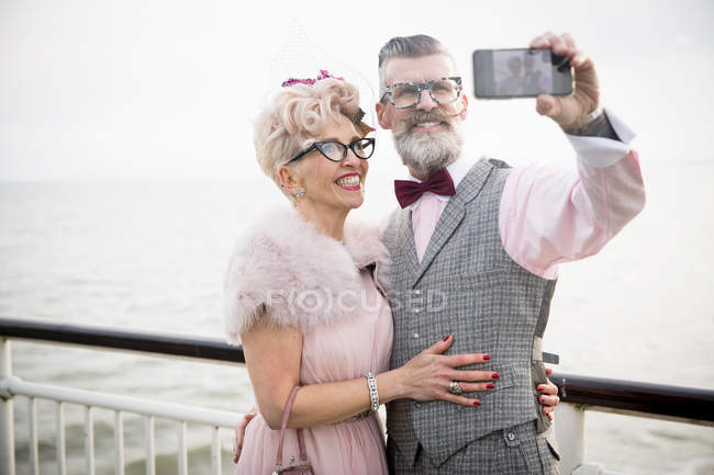 Couple taking smartphone selfie on pier — Stock Photo