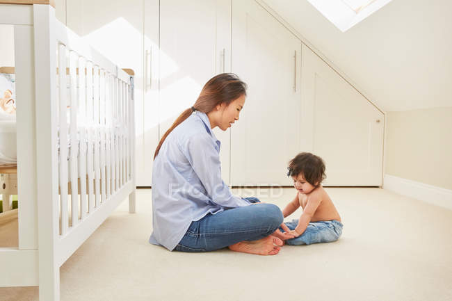 Woman sitting on floor with daughter — Stock Photo