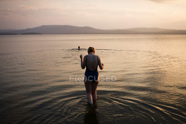 Mujer caminando en aguas poco profundas - foto de stock