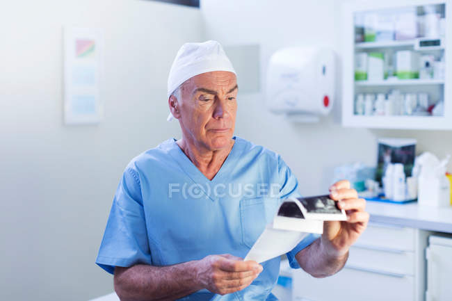 Médico mirando escaneo médico - foto de stock