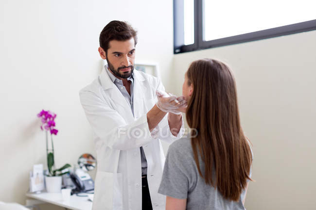 Cosmetic surgeon marking patient's face for surgery — Stock Photo