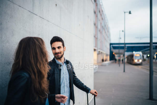 Casal em pé por parede cinza — Fotografia de Stock