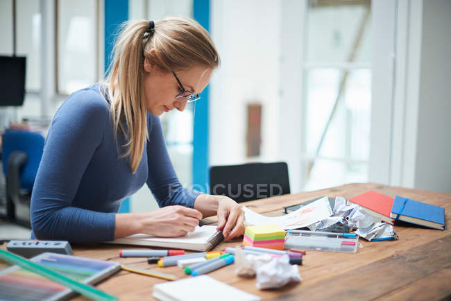 Female designer making notes — Stock Photo
