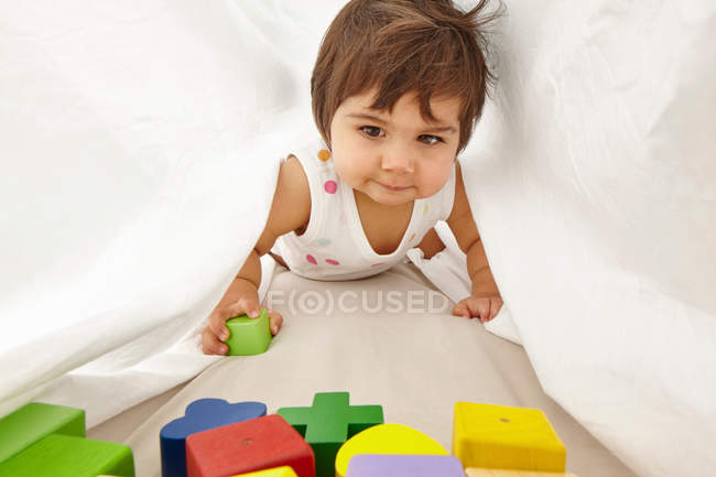 Toddler, crawling between sheets — Stock Photo