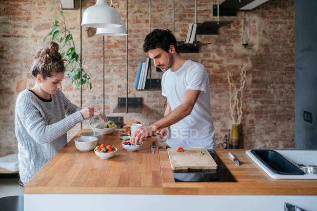 Casal preparando café da manhã no balcão da cozinha — Fotografia de Stock