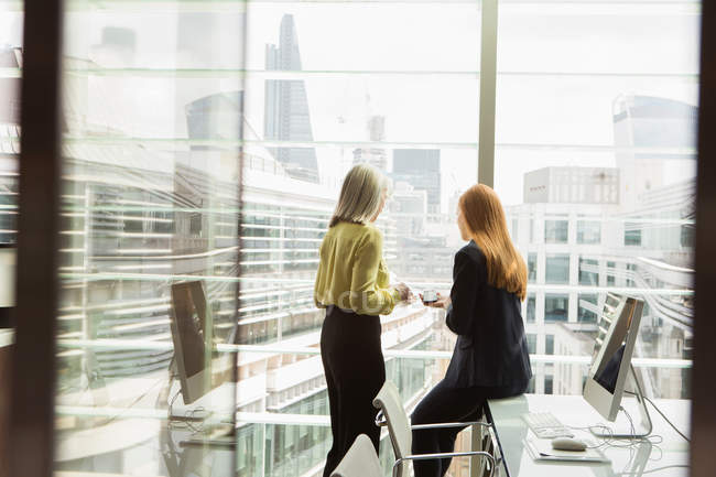Geschäftsfrauen reden im Büro am Fenster — Stockfoto
