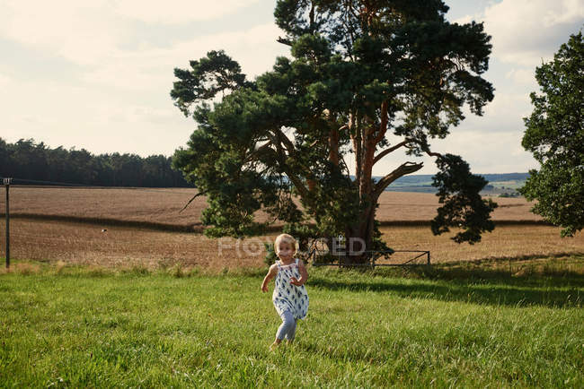 Criança correndo através do campo — Fotografia de Stock