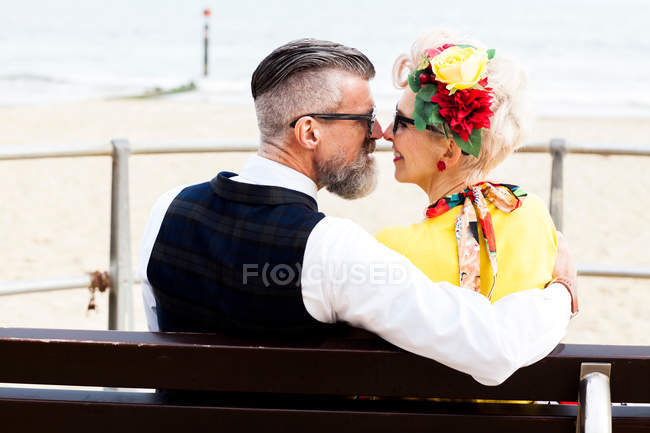 Couple face to face on bench at beach — Stock Photo