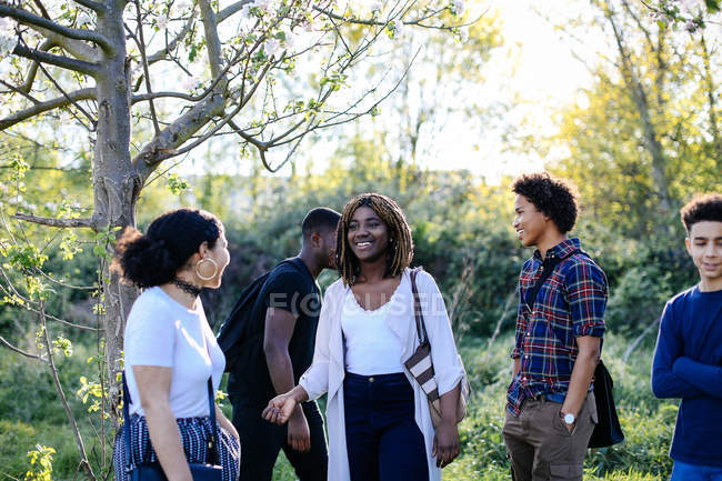 Group of friends, walking through park — Stock Photo