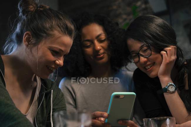 Friends looking at mobile phone — Stock Photo