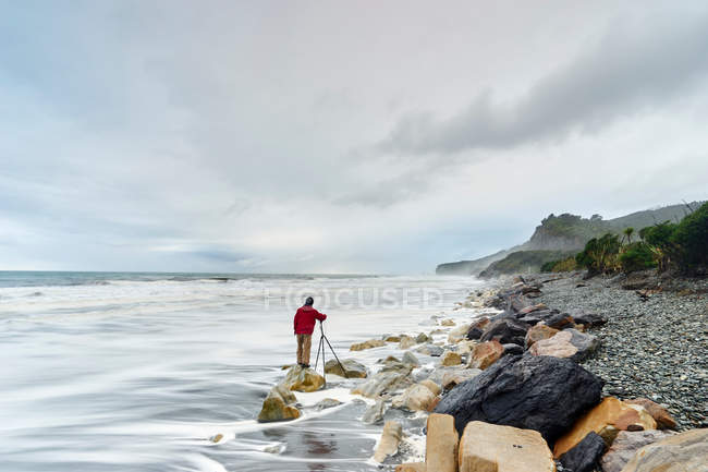 Tourist at edge of sea — Stock Photo