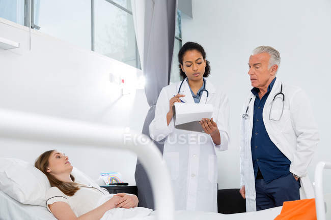 Doctors consulting with patient — Stock Photo