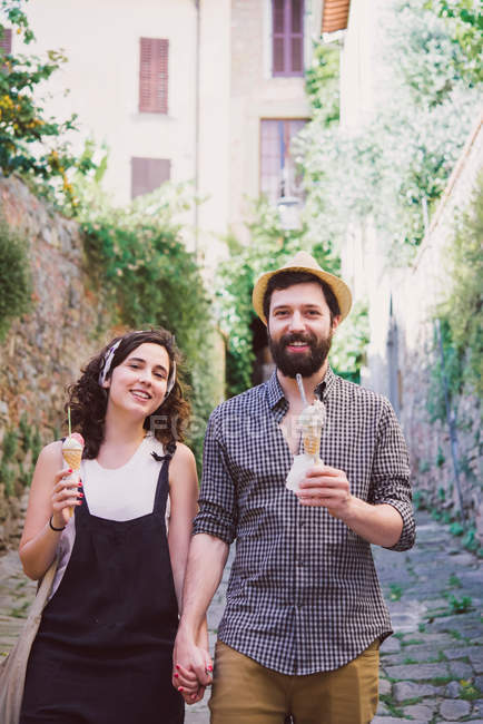 Couple with ice cream cones on cobbled street — Stock Photo