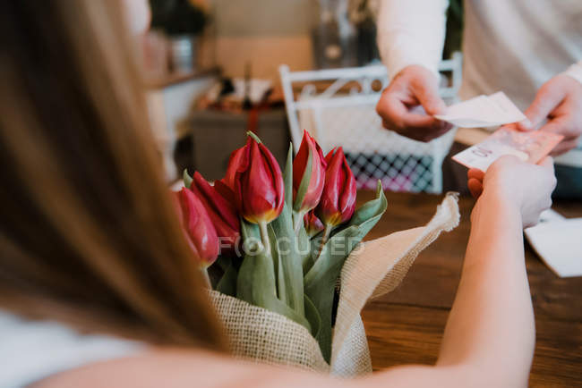 Donna che compra fiori nel negozio di fiori — Foto stock