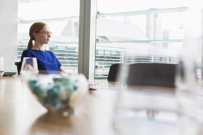 Деловая женщина, выглядывающая из окна офиса — стоковое фото