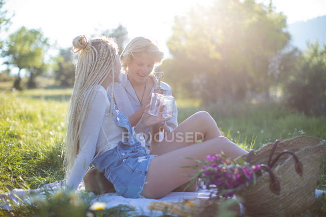 Casal em cobertor de piquenique no campo — Fotografia de Stock