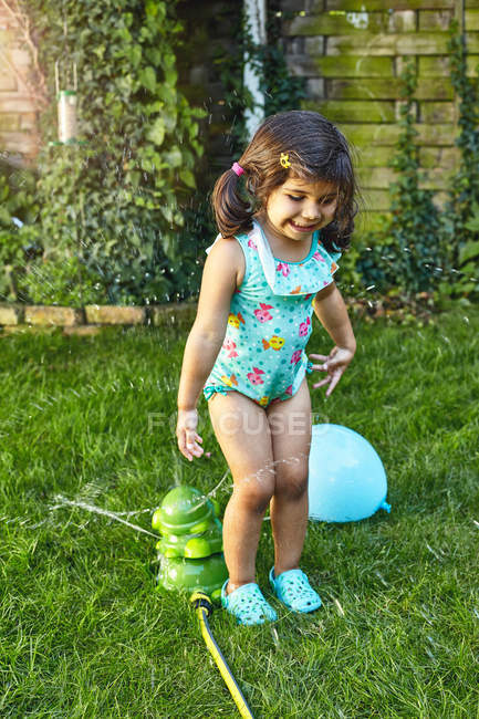 Chica joven jugando en el jardín - foto de stock