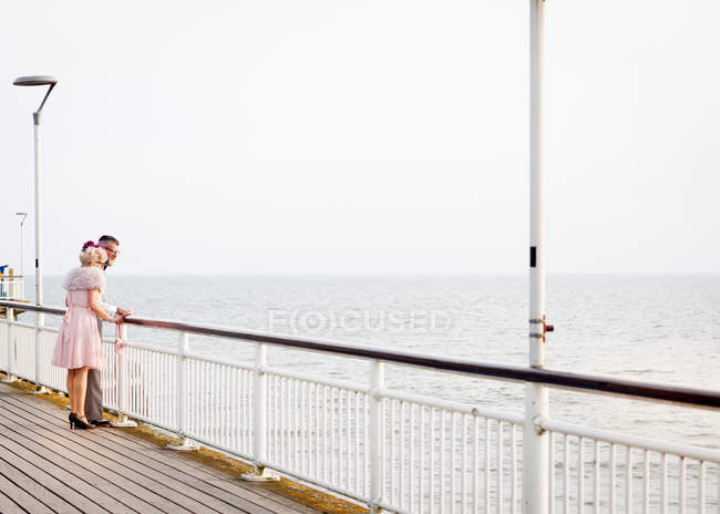 Paar schaut von Seebrücke aus — Stockfoto