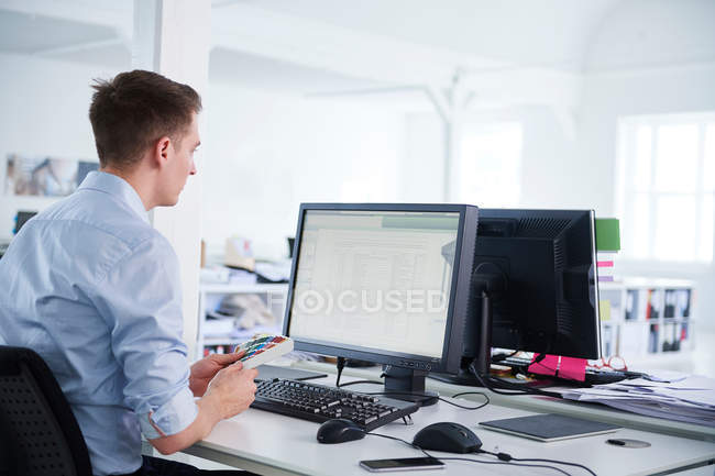 Чоловік в офісі за допомогою комп'ютера — стокове фото