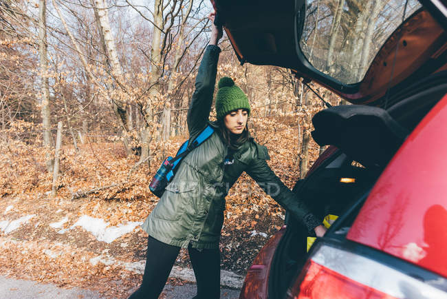 Female hiker unpacking car boot — Stock Photo