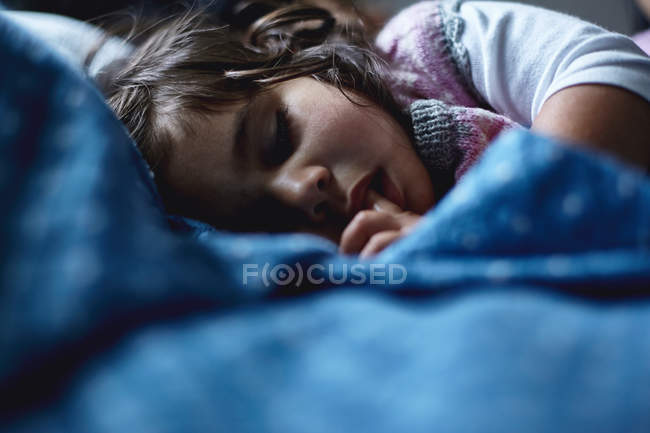 Giovane ragazza che dorme a letto — Foto stock