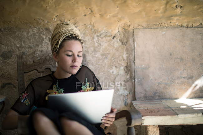 Jeune femme avec dreadlocks en utilisant une tablette numérique — Photo de stock