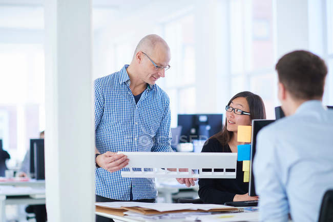 Колеги в офісі дивляться на архітектурну модель — стокове фото