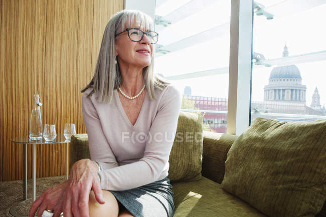 Donna d'affari seduta sul divano in ufficio — Foto stock